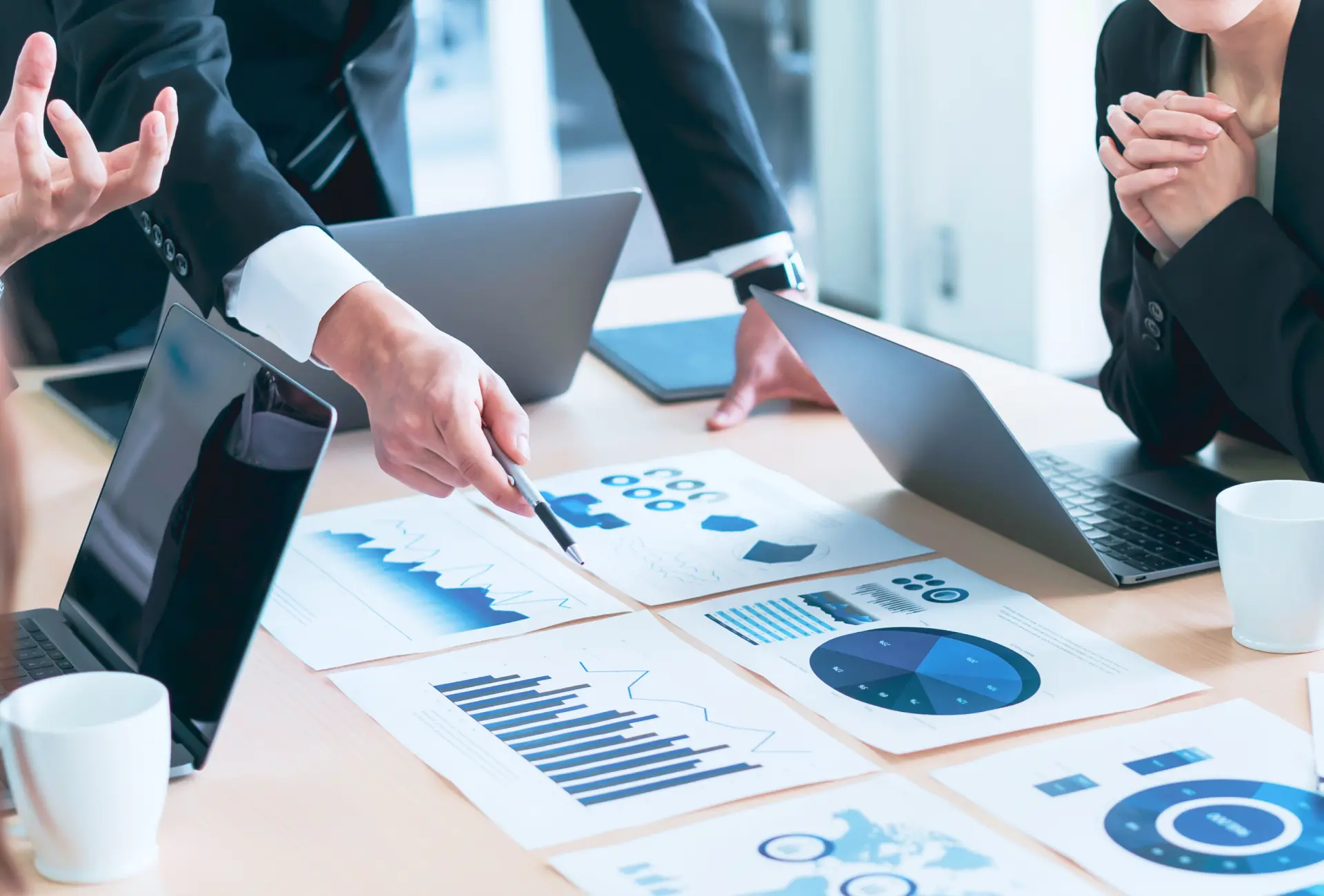 紙に印刷したデータを見ながら話し合っている様子