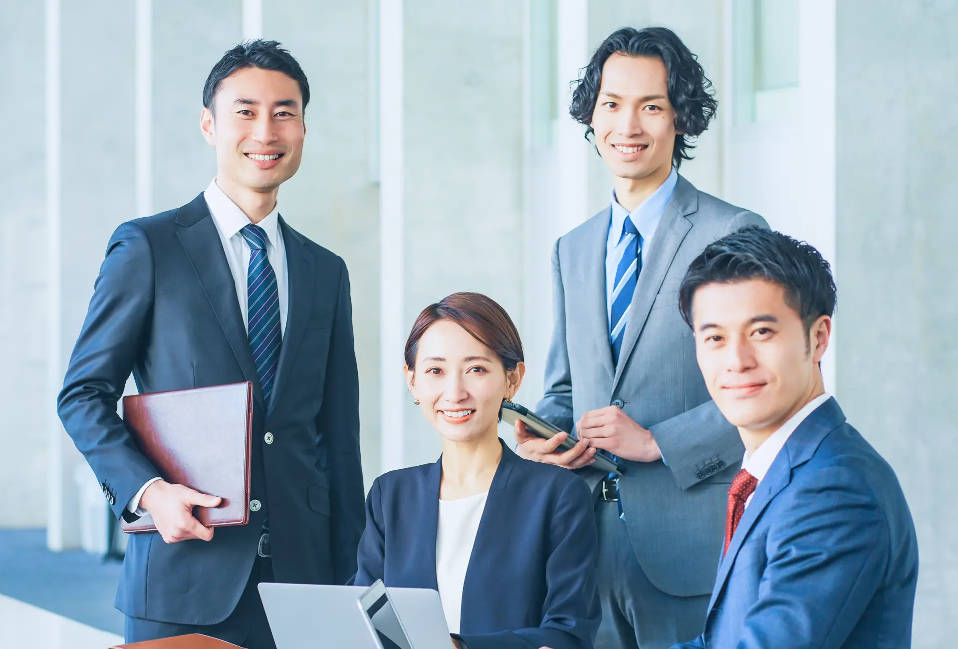 笑顔で正面を見ている4人の社員の写真