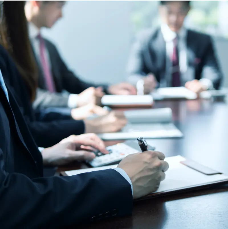 スーツを着た人たちが会議をしている様子